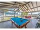Covered patio features a pool table and outdoor seating, creating a fun and inviting entertainment area at 401 Gannet Ct, Kissimmee, FL 34759