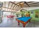 Spacious covered patio with a pool table, seating, and exercise equipment for outdoor enjoyment at 401 Gannet Ct, Kissimmee, FL 34759