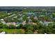 Community aerial view showcasing homes, trees, lake, pool, and tennis courts at 413 Pursley Dr, Deland, FL 32724