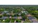 Scenic aerial view featuring a community, lake, swimming pool, and lush green trees at 413 Pursley Dr, Deland, FL 32724