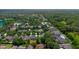 Aerial view of a residential neighborhood with a pool, tennis courts, and a tranquil lake at 413 Pursley Dr, Deland, FL 32724
