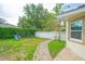Charming backyard features a paved walkway, grassy area, playground, and white fencing at 413 Pursley Dr, Deland, FL 32724