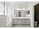 Bathroom featuring double sinks, stylish flooring, soaking tub, and natural light at 413 Pursley Dr, Deland, FL 32724