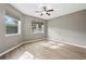 This bedroom features neutral walls, light-colored wood floors, two windows, and a ceiling fan at 413 Pursley Dr, Deland, FL 32724