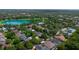 Aerial view shows a neighborhood community featuring a lake, pool, and mature trees at 413 Pursley Dr, Deland, FL 32724