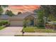 Charming single-story home with stone accents, blue door, attached garage, and manicured lawn at 413 Pursley Dr, Deland, FL 32724