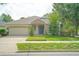 Well-maintained home with a stone entryway, a two-car garage, and established landscaping at 413 Pursley Dr, Deland, FL 32724