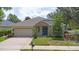 Inviting home featuring stone accents, a well-maintained lawn, and a welcoming blue front door at 413 Pursley Dr, Deland, FL 32724