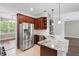 Kitchen features stainless steel refrigerator, granite counters, dark wood cabinets and eat-in space at 413 Pursley Dr, Deland, FL 32724