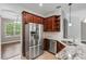 Kitchen features stainless steel refrigerator, granite counters, dark wood cabinets and eat-in space at 413 Pursley Dr, Deland, FL 32724