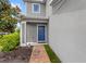 Charming blue front door with brick walkway and beautiful landscaping at 4301 Creek Bank Dr, Kissimmee, FL 34744