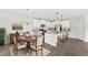 Open concept kitchen and dining area with white cabinets, stainless appliances, and gray plank floors at 4301 Creek Bank Dr, Kissimmee, FL 34744