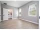 Spacious bedroom boasts light gray walls, wood-look flooring, and two windows, with ensuite bath at 4409 W Gore Ave, Orlando, FL 32811