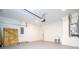 Spacious two-car garage with ample storage and work space featuring light grey painted flooring at 4409 W Gore Ave, Orlando, FL 32811