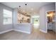Stylish kitchen featuring white cabinetry, modern pendant lighting, and sleek countertops open to the living area at 4409 W Gore Ave, Orlando, FL 32811