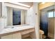 Well-lit bathroom featuring a wide mirror, tiled countertop, and a shower with a patterned curtain at 452 Sundown Trl, Casselberry, FL 32707