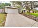 Inviting home exterior featuring a two-car garage, neutral siding, and stone-lined flower beds and driveway at 452 Sundown Trl, Casselberry, FL 32707