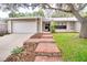 Charming single-story home with brick pathway and a well-manicured lawn under a mature tree at 452 Sundown Trl, Casselberry, FL 32707