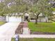Inviting single-story home with a well-manicured lawn, brick-lined garden beds, and a mature shade tree at 452 Sundown Trl, Casselberry, FL 32707