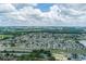 An aerial view of a neighborhood with lots of trees, a lake, and a highway in the distance at 5259 Images Cir # 301, Kissimmee, FL 34746