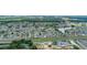 Aerial view of a neighborhood with lots of trees, a lake, and a highway in the distance at 5259 Images Cir # 301, Kissimmee, FL 34746