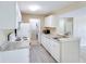 Well-equipped kitchen with white appliances, granite countertop, white cabinets and adjacent laundry area for convenience at 5259 Images Cir # 301, Kissimmee, FL 34746