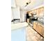 Kitchen featuring light wood cabinets, stainless steel appliances, tile backsplash, and tile floors at 5500 Devonbriar Way # 202, Orlando, FL 32822