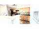 Kitchen view featuring light wood cabinets, black appliances, tiled backsplash, and breakfast bar at 5500 Devonbriar Way # 202, Orlando, FL 32822