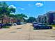 Image of a community parking lot featuring residential buildings, parked vehicles, and mature trees at 5500 Devonbriar Way # 202, Orlando, FL 32822