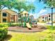 Bright community playground with slide, climbing equipment, surrounded by grass and shade at 5500 Devonbriar Way # 202, Orlando, FL 32822