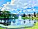 Scenic community pond with a fountain, surrounded by lush landscaping and residential buildings at 5500 Devonbriar Way # 202, Orlando, FL 32822