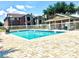 Resort-style community pool, surrounded by lounge chairs, overlooks well-maintained landscaping at 5500 Devonbriar Way # 202, Orlando, FL 32822