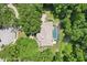Aerial view of home surrounded by mature trees with private pool and lush landscaping at 621 Estates Pl, Longwood, FL 32779