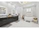 Bright bathroom with an elegant chandelier, double vanity, soaking tub, and stylish fixtures at 621 Estates Pl, Longwood, FL 32779