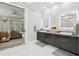 Elegant bathroom featuring double vanity with LED mirrors, and an adjacent bedroom with a sitting area at 621 Estates Pl, Longwood, FL 32779