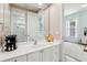 Bathroom vanity with a large mirror and white cabinets, leading into an adjacent bedroom with natural light at 621 Estates Pl, Longwood, FL 32779