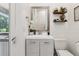 Bright bathroom with a gray wood vanity, floral accents and natural light at 621 Estates Pl, Longwood, FL 32779