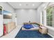 Modern bedroom with blue rug, TV, a built-in headboard and large window providing natural light at 621 Estates Pl, Longwood, FL 32779