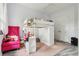 Cozy bedroom featuring a unique loft bed with desk, soft pink rug, and a vibrant pink armchair at 621 Estates Pl, Longwood, FL 32779