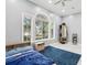 A well-lit bedroom has a large arched window offering a view of the outdoors, and a comfortable bed with blue accents at 621 Estates Pl, Longwood, FL 32779