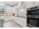 Bright kitchen with modern white cabinetry, stainless steel appliances, and a decorative backsplash at 621 Estates Pl, Longwood, FL 32779