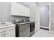 A laundry room featuring stainless steel washer/dryer, a utility sink, and modern cabinetry at 621 Estates Pl, Longwood, FL 32779