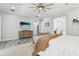 Bright main bedroom with a neutral palette, large bed, TV, and sitting area leading to the ensuite bathroom at 621 Estates Pl, Longwood, FL 32779