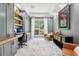 Home office with custom built-in shelving, desk, plush chairs, and large windows at 621 Estates Pl, Longwood, FL 32779