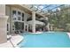 Spacious in-ground pool inside screened enclosure with spiral staircase and fireplace at 621 Estates Pl, Longwood, FL 32779