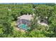 Aerial view of a screened in pool and paver patio surrounded by lush green trees at 621 Estates Pl, Longwood, FL 32779