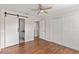 Spacious bedroom featuring barn door entry to bathroom, dual closets, and ceiling fan at 628 Olympic Dr # 8-C, Ocoee, FL 34761
