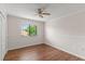 Well-lit bedroom showcasing a window with tree view and hardwood flooring at 628 Olympic Dr # 8-C, Ocoee, FL 34761