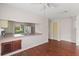Open living space with wood-look floors, ceiling fan and pass-through to the kitchen at 628 Olympic Dr # 8-C, Ocoee, FL 34761