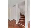 Hardwood staircase with white railing and trim, and small closet on landing at 628 Olympic Dr # 8-C, Ocoee, FL 34761